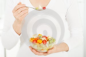 Fruit salad in the hands of women.