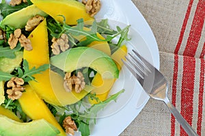 Fruit salad with mango, avocado, rucola and walnuts