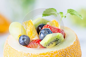 Fruit salad in melon on wooden table