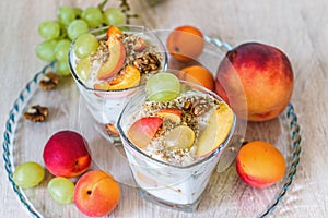 Fruit salad with soft cottage cheese and walnuts in glass bowl