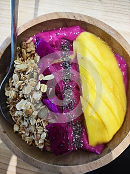 Fruit salad with sweet mango, dragon fruit and a lot of peanut crumbles