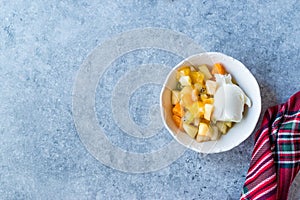 Fruit Salad with Vanilla Ice Cream in Ceramic Bowl