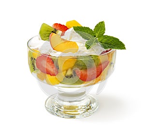 Fruit salad with whipped cream isolated on a white background.