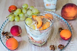 Fruit salad with yogurt and walnuts in glass bowl