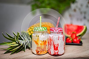 Fruit smoothies in glass jars with straws. Strawberry