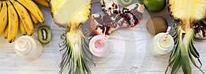 Fruit smoothies or milkshakes of various tastes in glass bottles with ingredients on white wooden background, top view. From above