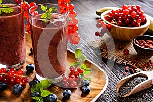 Fruit smoothies with red currants, blueberry, banana, goji berries and chia seeds