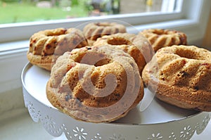 Fruit sponge cakes served on a decorative dish on a kitchen counter top.