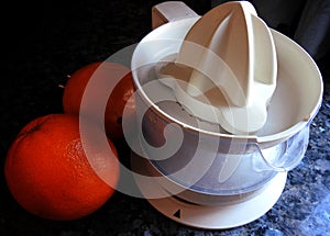 Fruit squeezer and two oranges