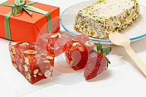 Fruit sweets with nuts and gift box on white background.