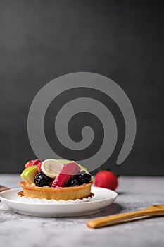 fruit tart dessert on black background with copy space