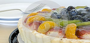 Fruit tart with fork and plates