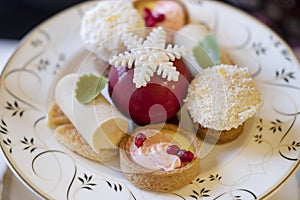 Fruit tartlets, cheesecakes, coconut marshmallow balls and a red chocolate sphere decorated with a sugar snowflake