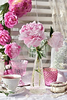 Fruit tea in beautiful porcelain cup and peony flowers