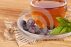 Fruit tea in cup with blackberry
