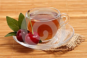 Fruit tea in cup with cherry