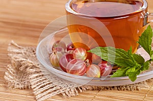 Fruit tea in cup with gooseberry