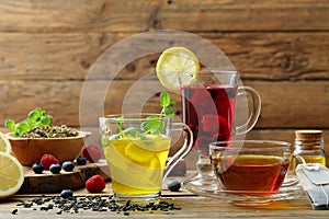 Fruit tea with ginger lemon and herbs in glass cup on rustic background photo