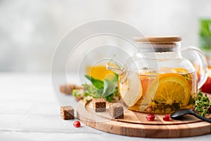 fruit tea with orange and apple in a glass teapot