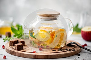 fruit tea with orange and apple in a glass teapot