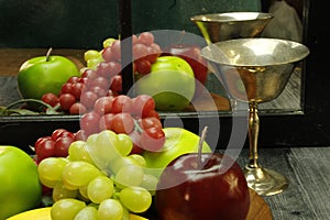 Fruit tray, silver wine glass with reflection through mirrored window