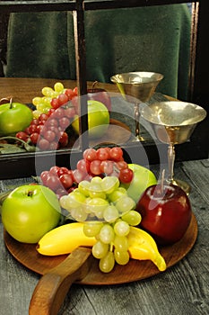 Fruit tray, silver wine glass with reflection through mirrored window