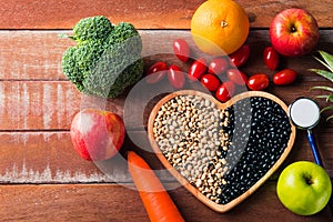 Fruit and vegetable in heart plate and doctor stethoscope