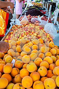 Fruit and vegetable market in Spain. Apples and peaches sold on outdoor market. Ripe sesonal farm fruits for sale