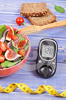 Fruit and vegetable salad and glucometer for checking sugar level with tape measure, concept of diabetes