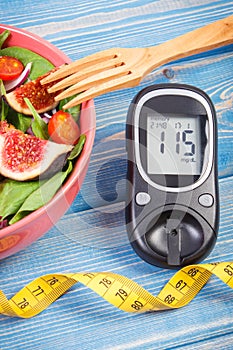 Fruit and vegetable salad and glucose meter with tape measure, concept of diabetes, slimming and healthy nutrition