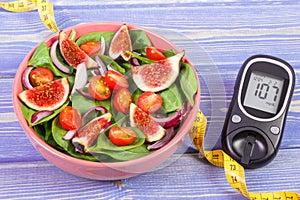 Fruit and vegetable salad and glucose meter with tape measure, concept of diabetes, slimming and healthy nutrition