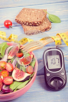 Fruit and vegetable salad and glucometer with tape measure, concept of diabetes, slimming and healthy nutrition