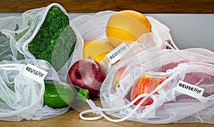 Fruit and Vegetables in reusable mesh bags, with reuse me labels, on kitchen counter