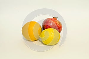 Fruit on a white background - orange, pomegranate, lemon