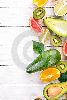 Fruit on a wooden background. Avocado, lime, orange, grapefruit and kiwi. Top view.