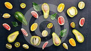 Fruit on a wooden background. Avocado, lime, orange, grapefruit and kiwi. Top view.