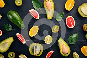 Fruit on a wooden background. Avocado, lime, orange, grapefruit and kiwi. Top view.