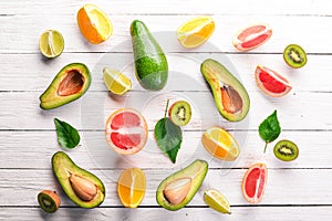 Fruit on a wooden background. Avocado, lime, orange, grapefruit and kiwi. Top view.