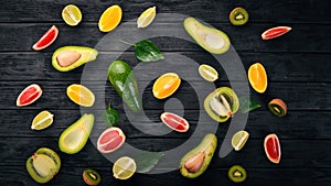 Fruit on a wooden background. Avocado, lime, orange, grapefruit and kiwi. Top view.