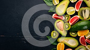 Fruit on a wooden background. Avocado, lime, orange, grapefruit and kiwi. Top view