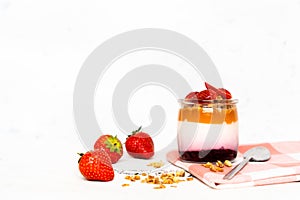 Fruit yogurt berry with muesli and fresh strawberries, on a white wooden background