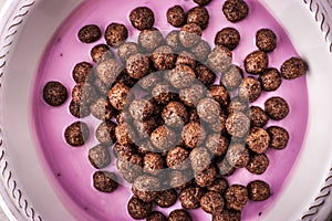 Fruit yogurt with crisp chocolate ball in the ceramic bowl close-up