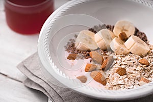 Fruit yogurt with different toppings on the white wooden table horizontal