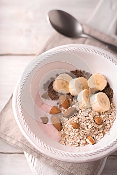 Fruit yogurt with different toppings on the white wooden table top view