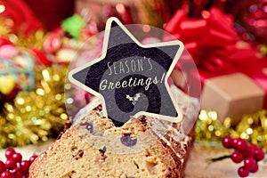 fruitcake topped with a chalkboard with the text seasons greetings