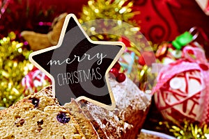 Fruitcake topped with a signboard with the text merry christmas