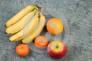 Fruits. Bananas, apples, oranges, tangerines on a biton background