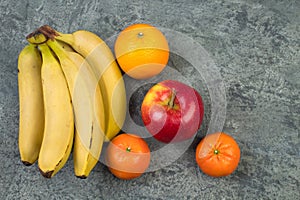 Fruits. Bananas, apples, oranges, tangerines on a biton background
