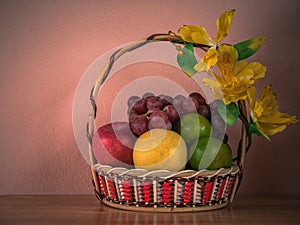 Fruits Basket on wooden table with wall concrete background, Still Light