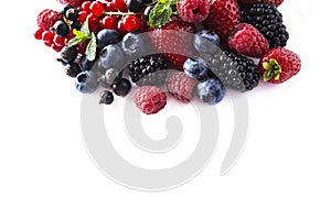 Fruits and berries isolated on white background. Ripe currants, raspberries, blueberries, strawberries and blackberries with a mi